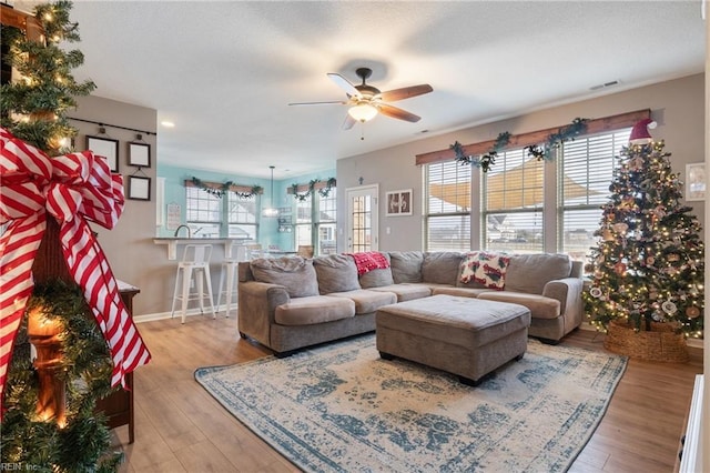 living room featuring ceiling fan and light wood-type flooring