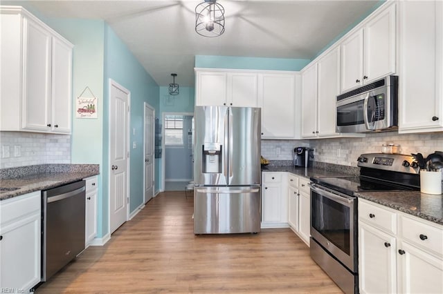 kitchen with decorative backsplash, light hardwood / wood-style floors, white cabinetry, and appliances with stainless steel finishes