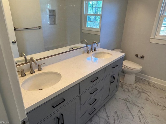 bathroom featuring vanity, toilet, and a healthy amount of sunlight