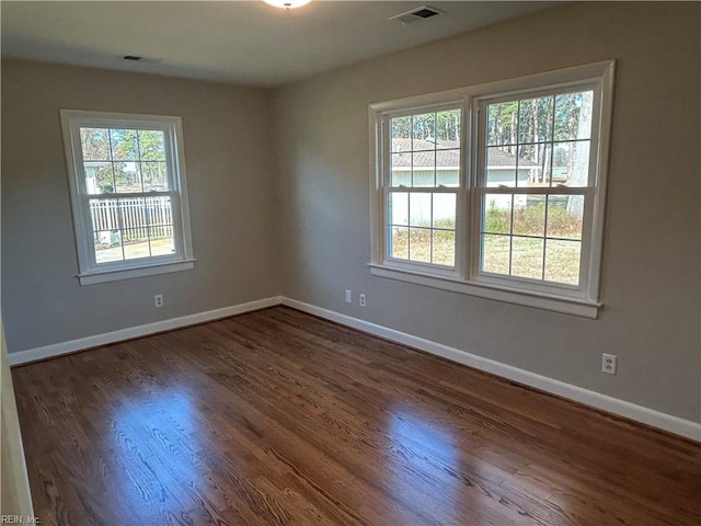 unfurnished room with dark hardwood / wood-style flooring