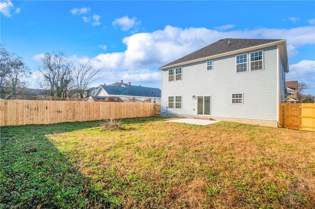 back of property with a lawn and a patio area