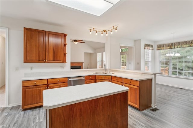 kitchen featuring sink, decorative light fixtures, ceiling fan with notable chandelier, and light hardwood / wood-style flooring