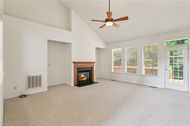 unfurnished living room with a wealth of natural light, high vaulted ceiling, light colored carpet, and ceiling fan