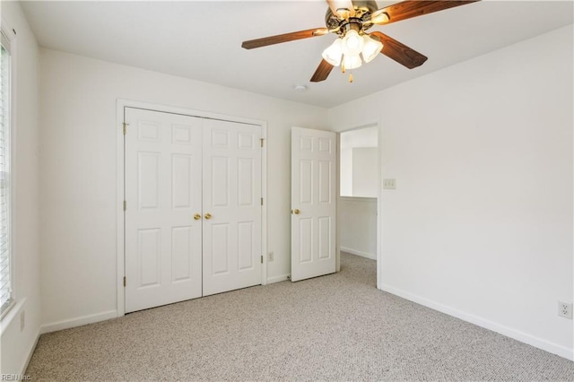 unfurnished bedroom with ceiling fan, light carpet, and a closet