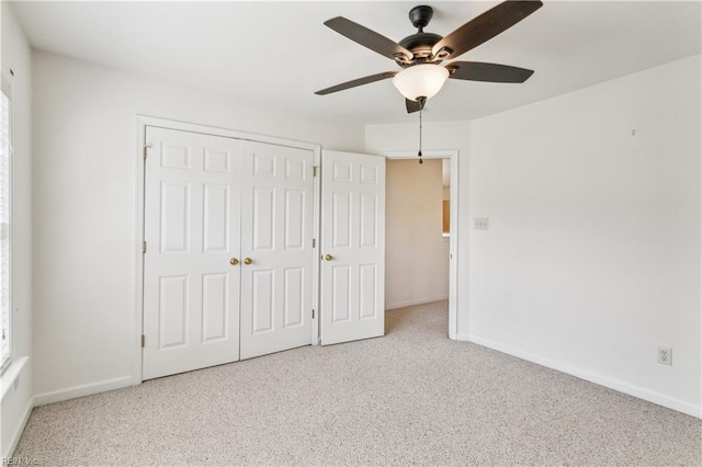 unfurnished bedroom with ceiling fan, light colored carpet, and a closet