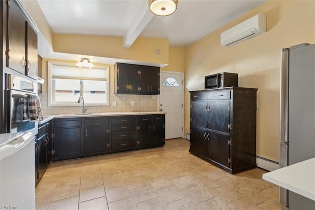 kitchen with a wall mounted air conditioner, appliances with stainless steel finishes, a wealth of natural light, and sink