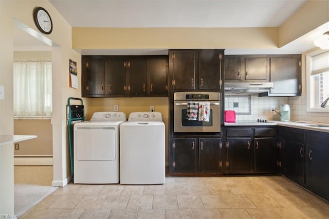 laundry area featuring sink, separate washer and dryer, baseboard heating, and light tile patterned floors