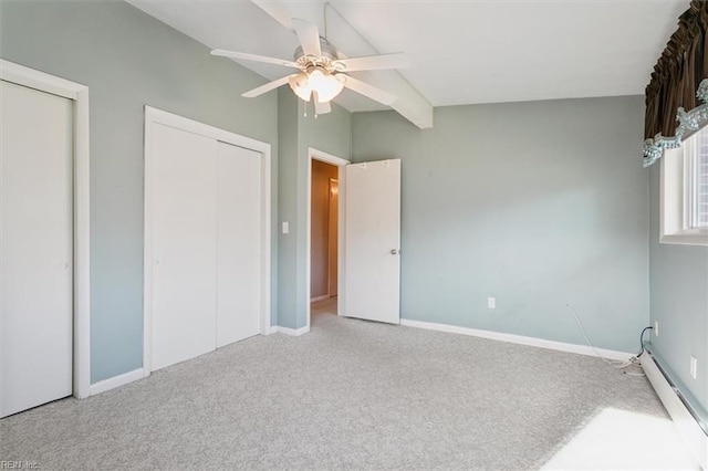 unfurnished bedroom with multiple closets, ceiling fan, a baseboard heating unit, vaulted ceiling, and carpet