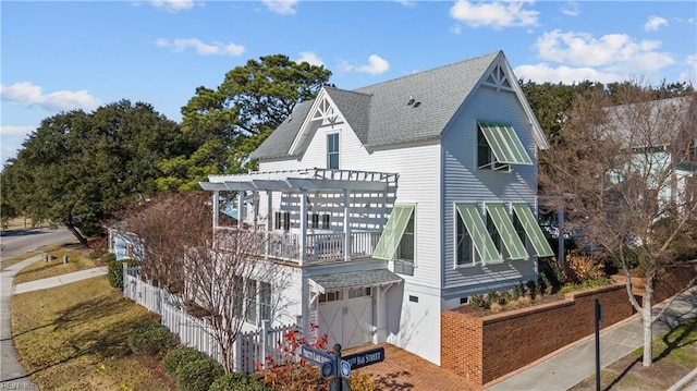 rear view of house featuring a balcony and a pergola