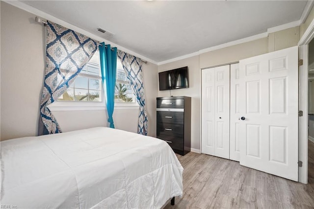 bedroom with crown molding, a closet, and light hardwood / wood-style flooring