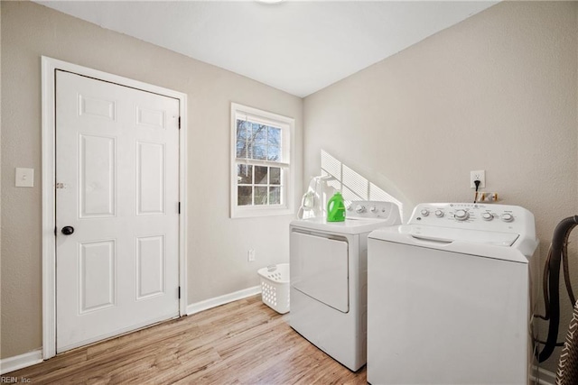 clothes washing area with light wood-type flooring and independent washer and dryer