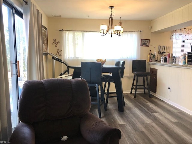 dining area featuring dark hardwood / wood-style floors, an inviting chandelier, and a healthy amount of sunlight