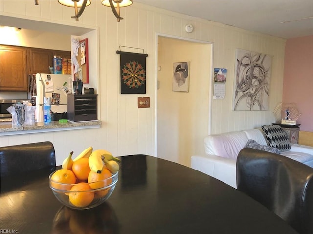 dining area with wooden walls and an inviting chandelier