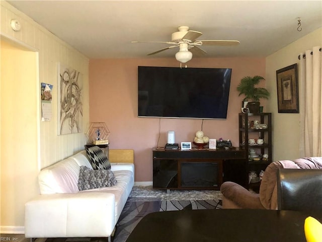 living room featuring ceiling fan and a fireplace