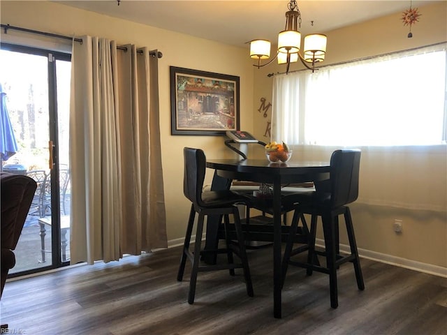 dining room with plenty of natural light, dark hardwood / wood-style floors, and a notable chandelier