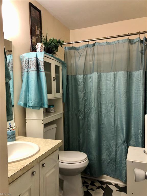 bathroom with vanity, a shower with shower curtain, and toilet