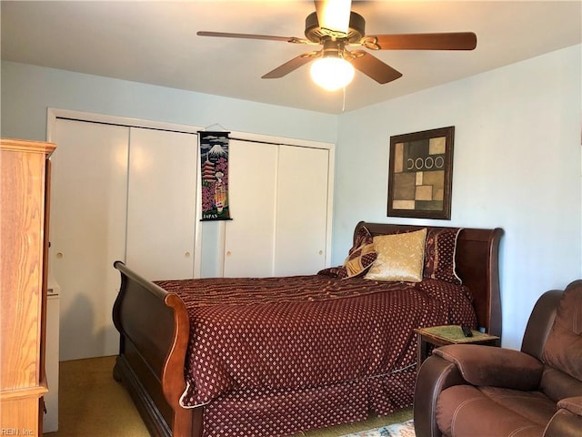 carpeted bedroom featuring two closets and ceiling fan