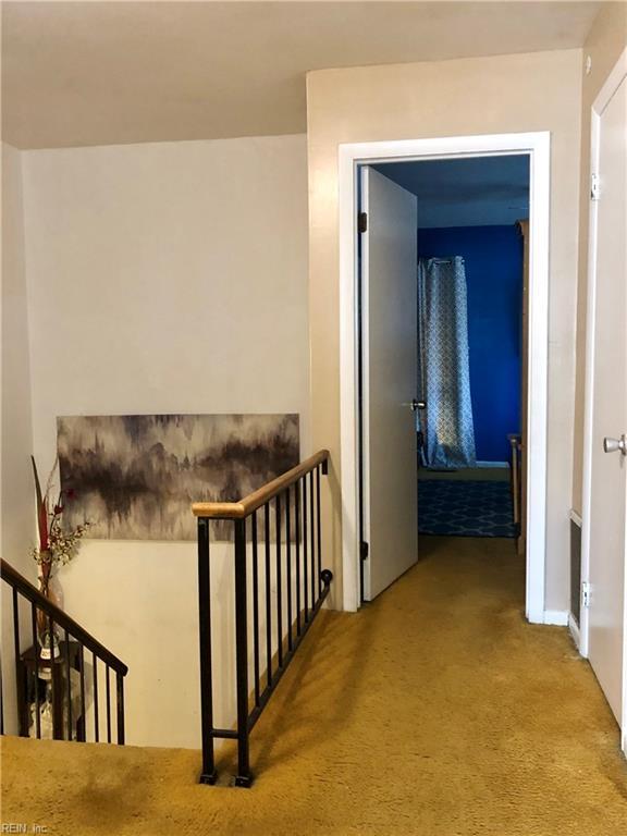 hall with light colored carpet