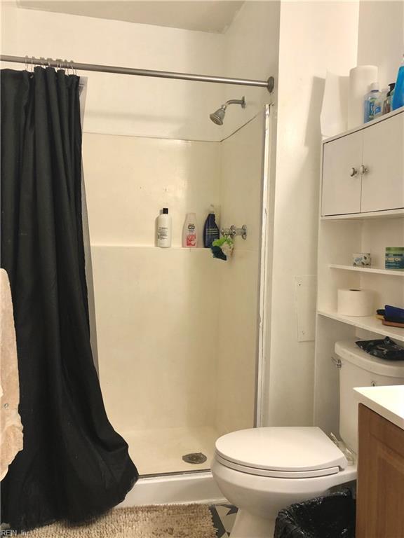 bathroom featuring a shower with curtain, vanity, and toilet