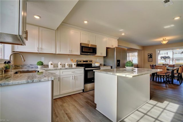 kitchen featuring sink, a kitchen island, light hardwood / wood-style floors, white cabinetry, and stainless steel appliances