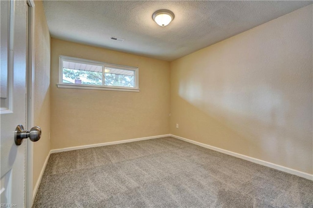 empty room featuring carpet and a textured ceiling