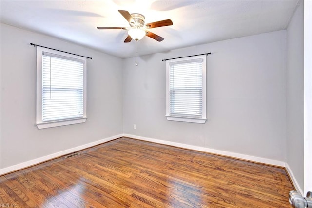 unfurnished room with hardwood / wood-style flooring, ceiling fan, and a healthy amount of sunlight