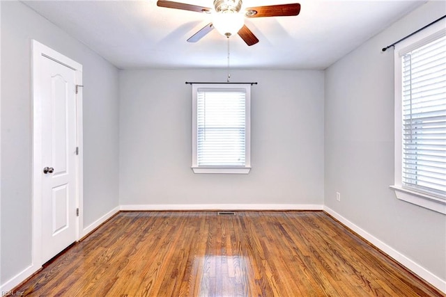 unfurnished room featuring a wealth of natural light, hardwood / wood-style floors, and ceiling fan