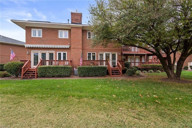 back of property with a deck and a yard