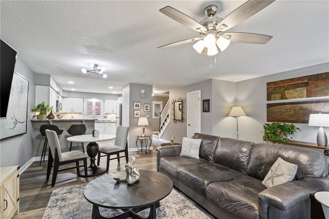 living room featuring a textured ceiling, dark hardwood / wood-style flooring, and ceiling fan