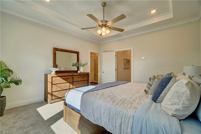 bedroom with ceiling fan, light colored carpet, crown molding, and a tray ceiling