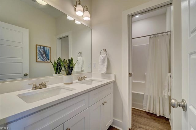 bathroom with shower / bathtub combination with curtain, hardwood / wood-style floors, and vanity