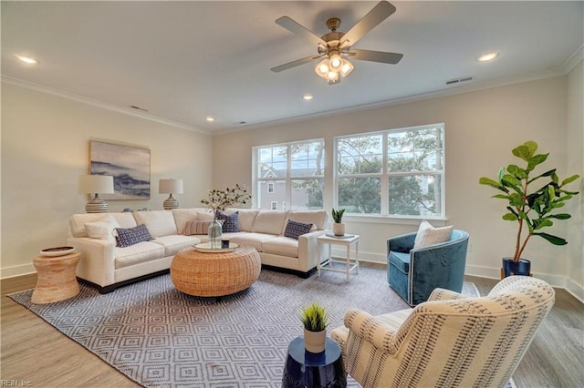 living room with wood-type flooring, ceiling fan, and ornamental molding