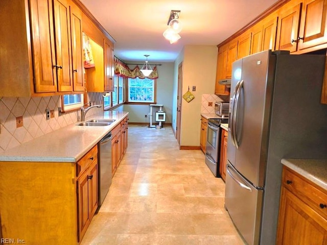 kitchen featuring sink, stainless steel appliances, hanging light fixtures, and tasteful backsplash