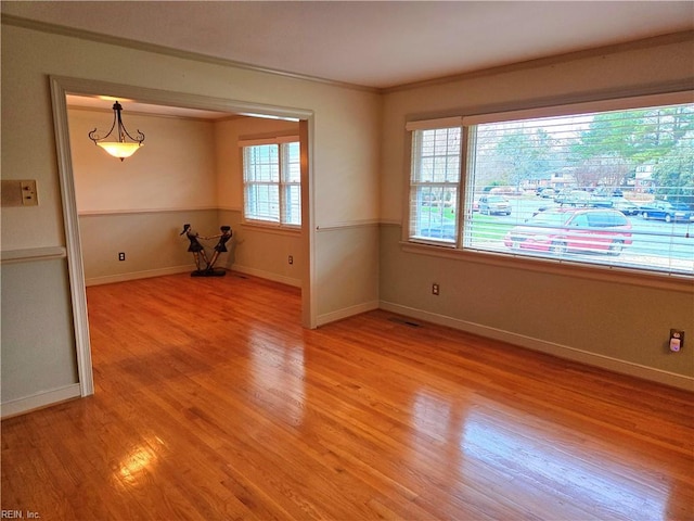 spare room with crown molding and light hardwood / wood-style floors