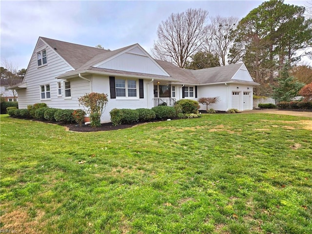 ranch-style home with covered porch, a front yard, and a garage