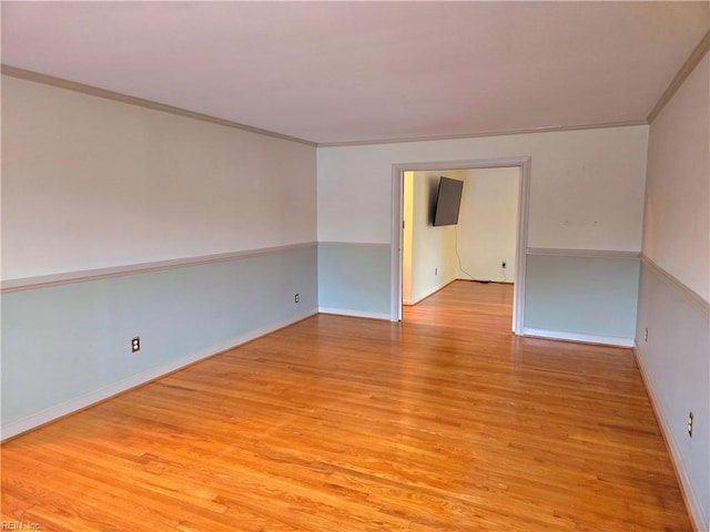 spare room with light wood-type flooring and ornamental molding