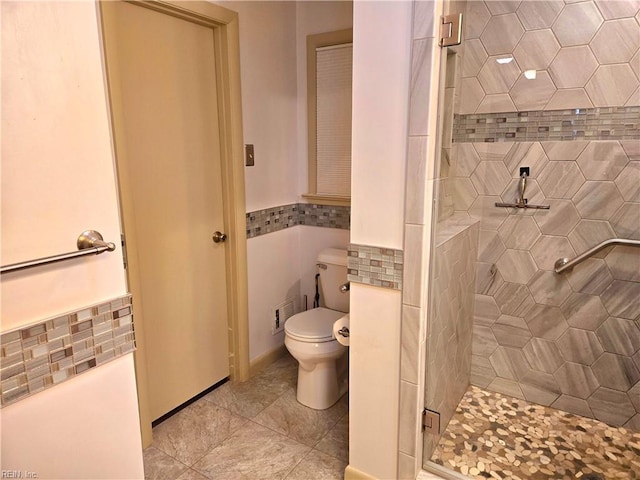 bathroom with toilet and a shower with door