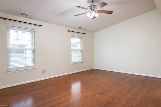 spare room with ceiling fan, a healthy amount of sunlight, and dark hardwood / wood-style flooring