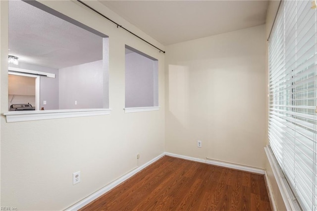 empty room featuring plenty of natural light and hardwood / wood-style flooring