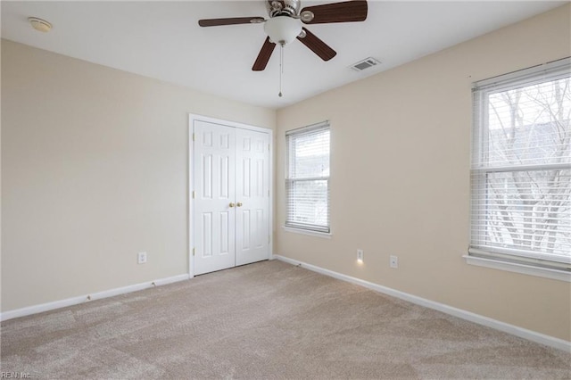 carpeted empty room featuring ceiling fan and a healthy amount of sunlight