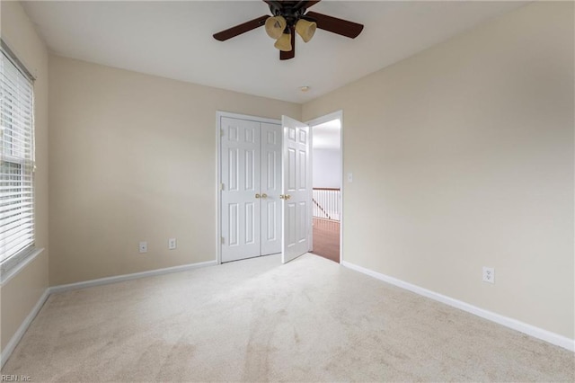 unfurnished bedroom with ceiling fan, a closet, and light colored carpet