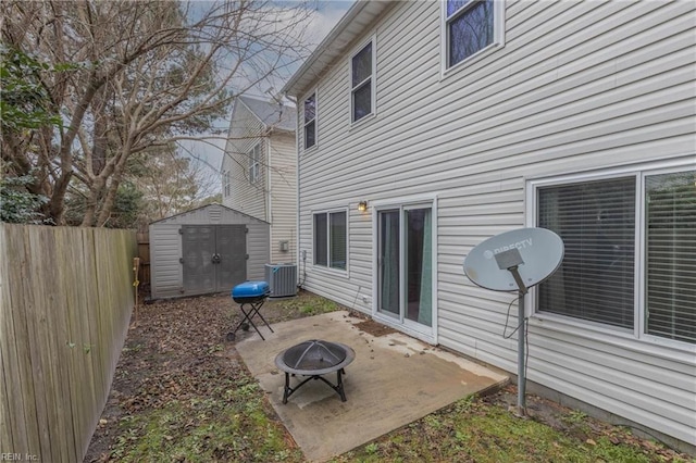 exterior space featuring central AC unit, a storage shed, and an outdoor fire pit