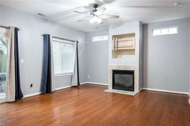 unfurnished living room featuring a fireplace, plenty of natural light, and hardwood / wood-style flooring