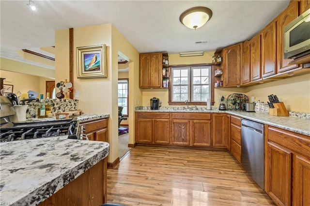 kitchen with sink, light wood-type flooring, and appliances with stainless steel finishes