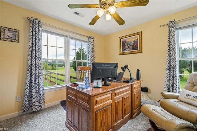 office area featuring a wealth of natural light, ceiling fan, and light colored carpet