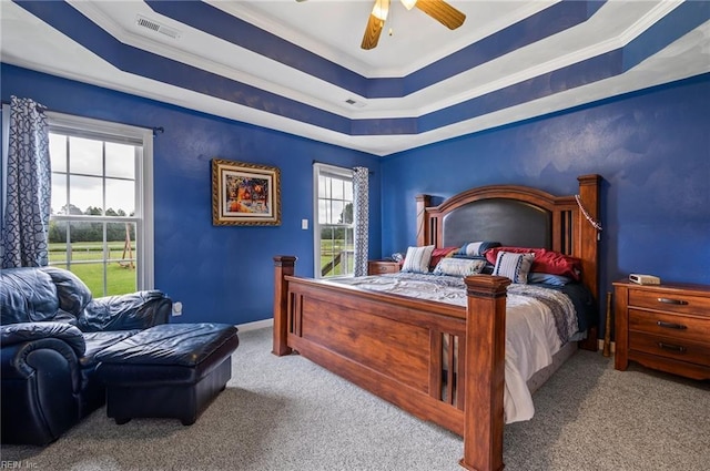 bedroom with a tray ceiling, ceiling fan, light colored carpet, and ornamental molding