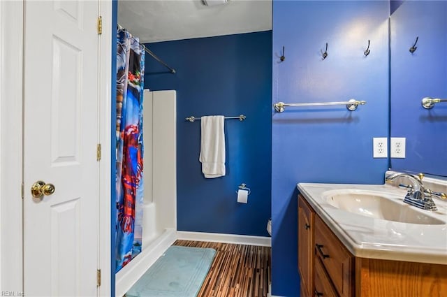 bathroom with a shower with shower curtain, hardwood / wood-style floors, and vanity