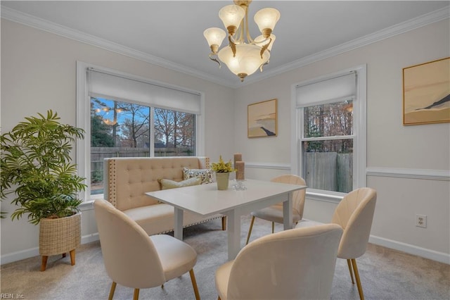 carpeted dining space with crown molding and an inviting chandelier