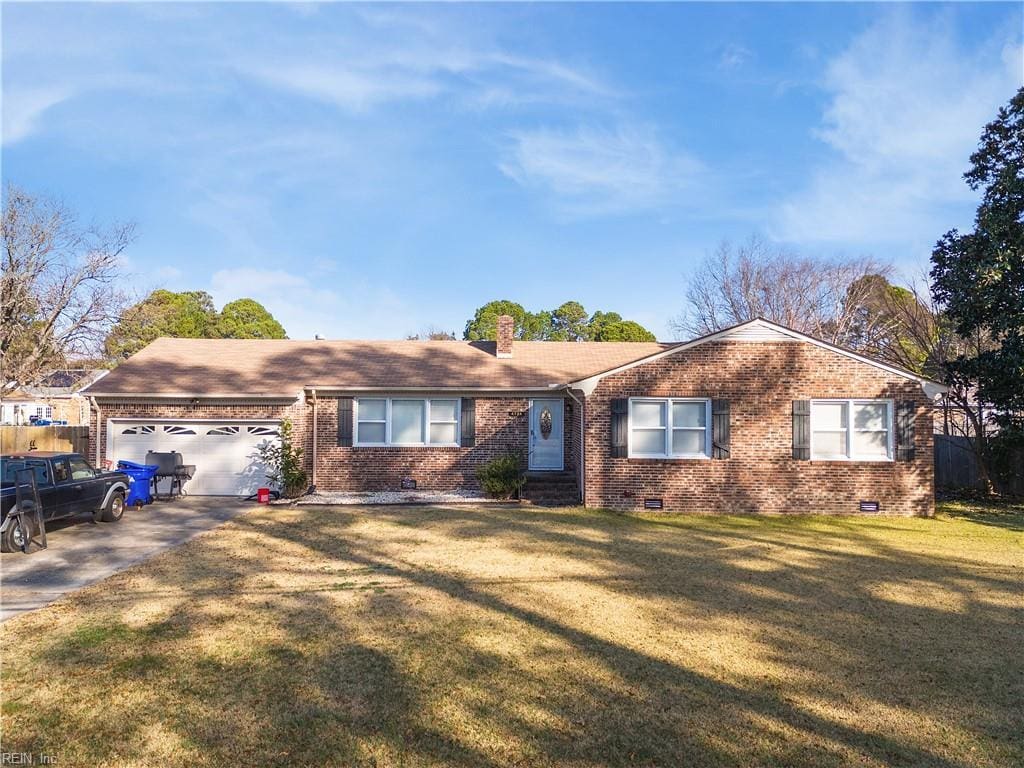 ranch-style house featuring a garage and a front lawn