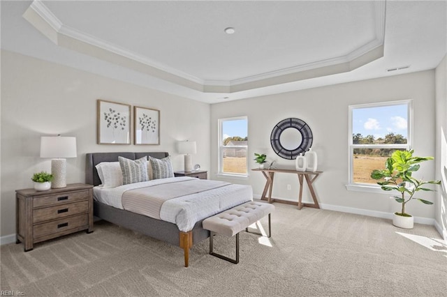 carpeted bedroom with crown molding, multiple windows, and a tray ceiling